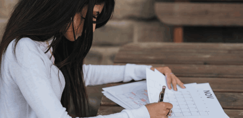 a manager creating a work schedule at a table on paper rather than using scheduling software