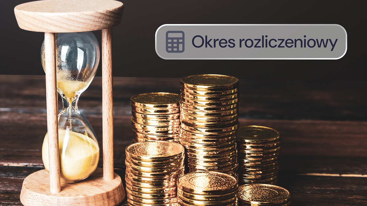 Klepsydra stoi obok stosów monet na drewnianym stole.