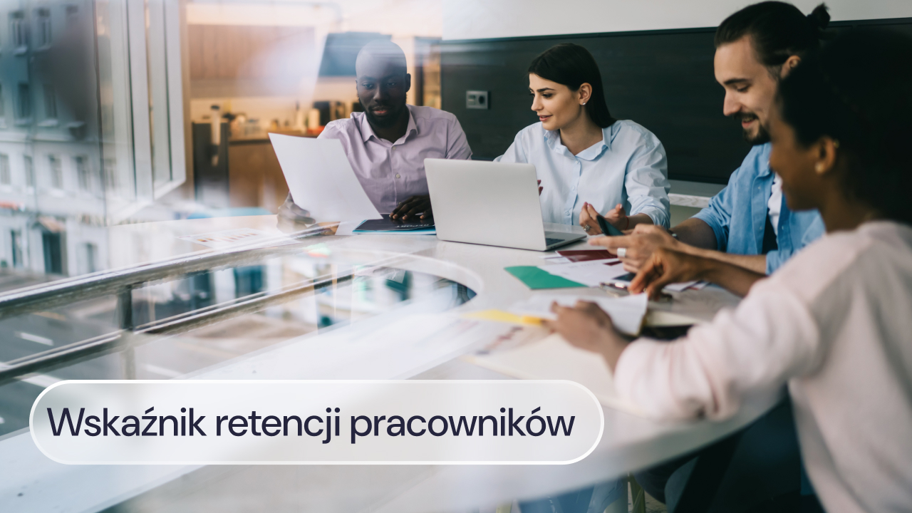 Pracownicy omawiają dokumenty i dane przy laptopie podczas spotkania w biurze.