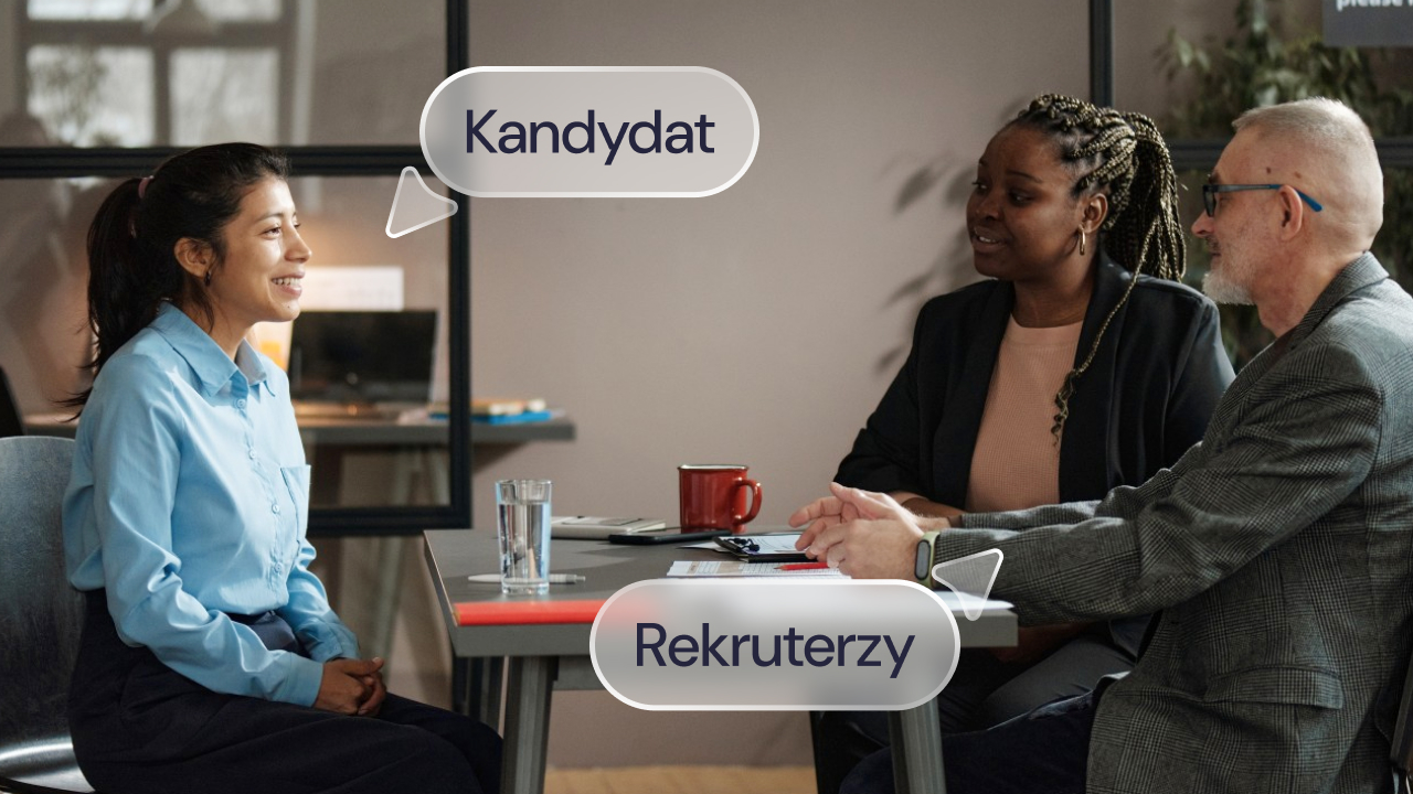 Rozmowa rekrutacyjna przy stole. Po lewej stronie siedzi kandydatka, po prawej dwoje rekruterów.