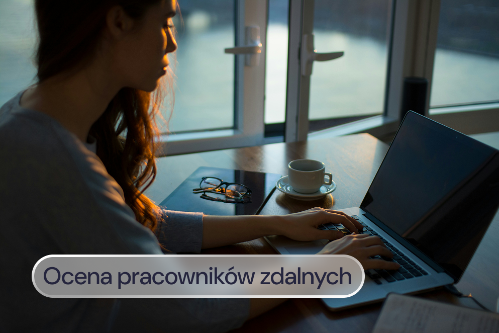 Osoba pracuje na laptopie przy oknie.