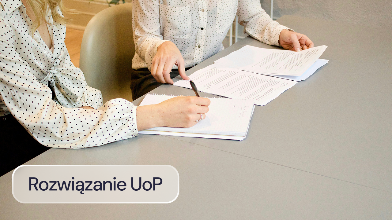 Pracownicy omawiają dokumenty dotyczące rozwiązania umowy.