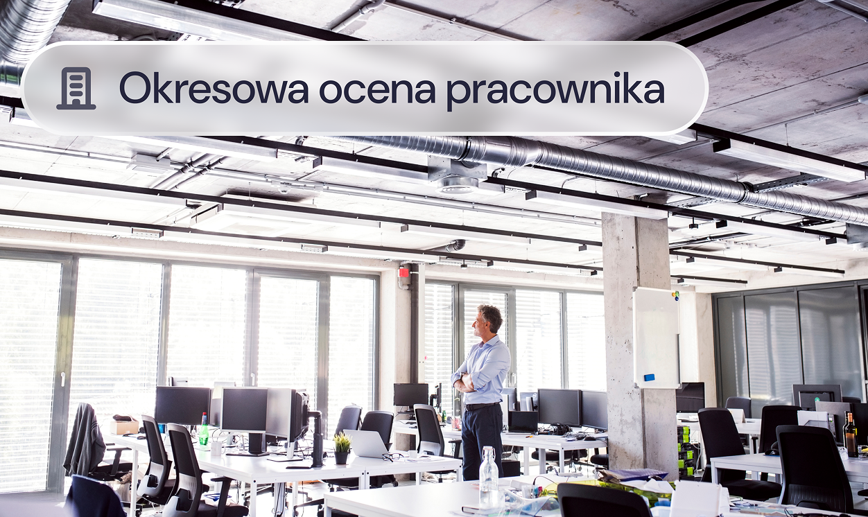 Menedżer stoi w pustym biurze przy stanowiskach pracy.
