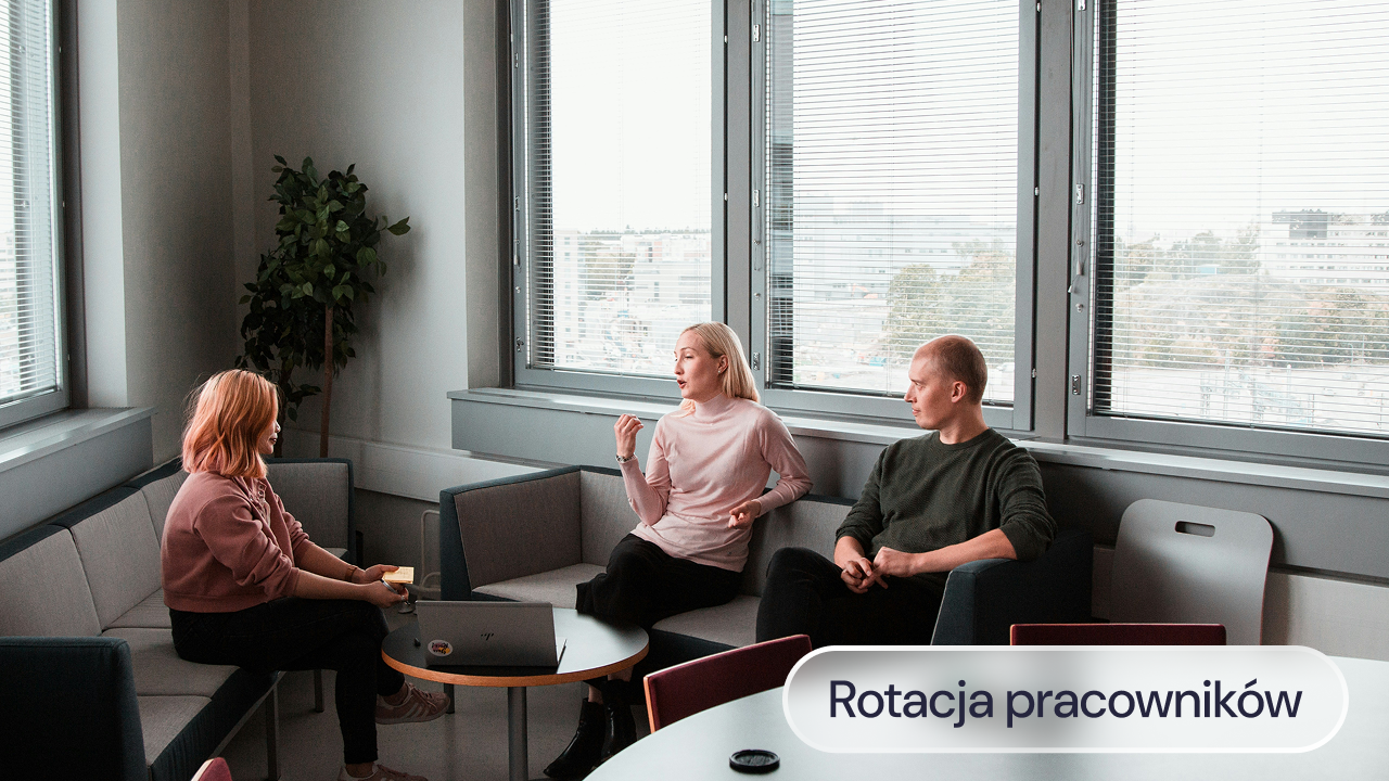 Trzech pracowników rozmawia przy stoliku w biurze.