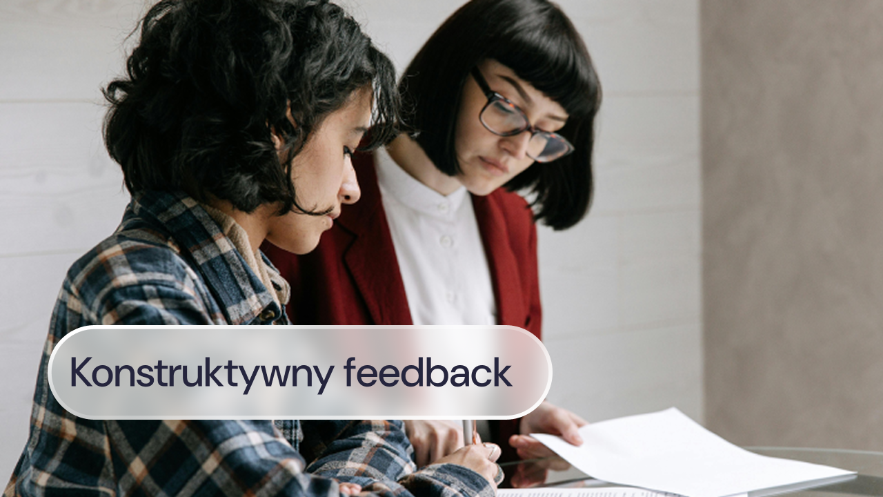 Przełożona udziela pracownikowi feedbacku podczas spotkania przy dokumentach.