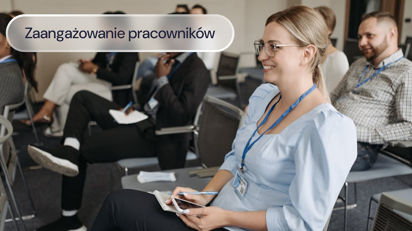 Uczestnicy szkolenia w sali konferencyjnej robią notatki i słuchają prowadzącego.
