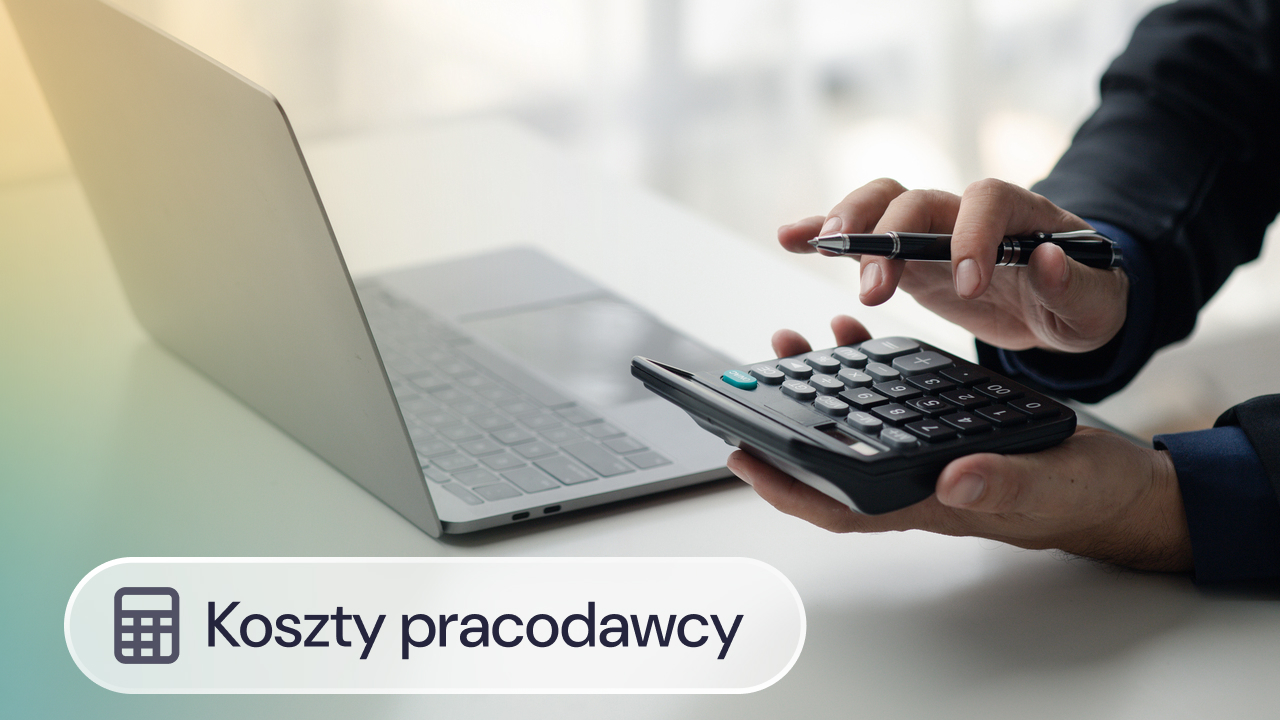Osoba wykonuje obliczenia na kalkulatorze przy laptopie.