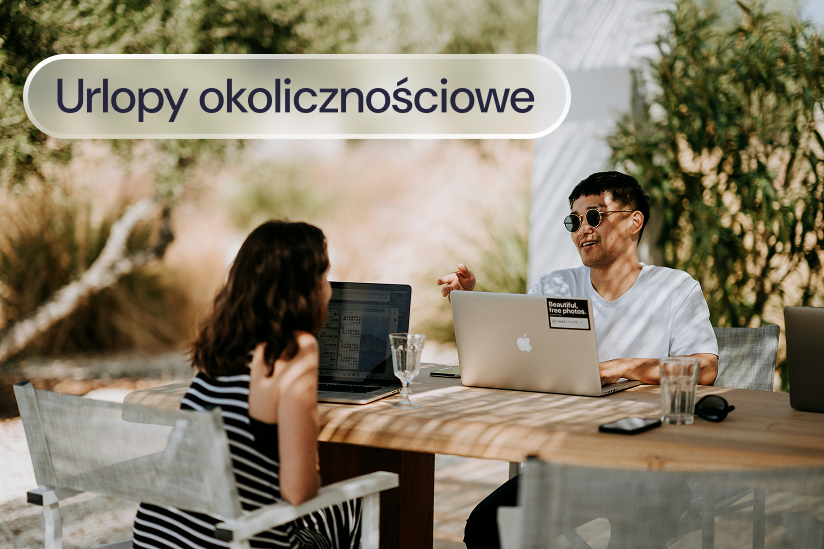 Kobieta i mężczyzna pracują na laptopach przy stole na zewnątrz.