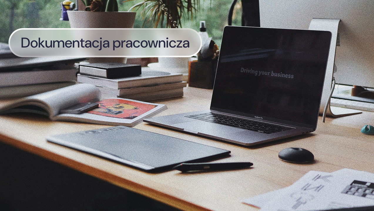 Biurko z laptopem, dokumentami i przyborami do pracy.