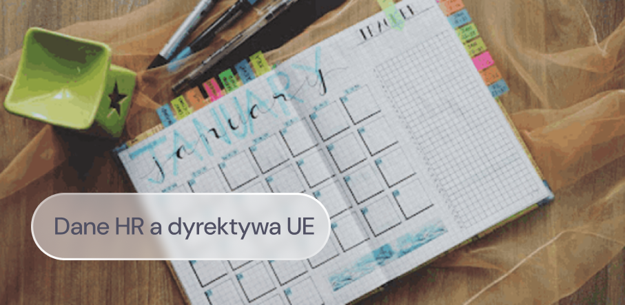 Otwarty planer z przyborami do pisania leży na biurku.